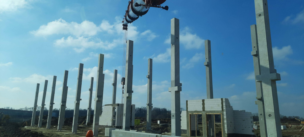 Filary budynku hali produkcyjnej postawione za pomocą żurawia samojezdnego