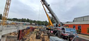 Żurawie samojezdne i dźwig wieżowy podczas prac budowlanych w Łodzi